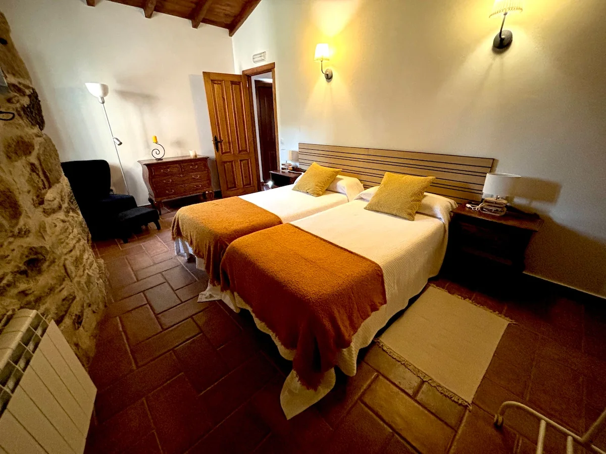 Dormitorio del apartamento 1371 con dos camas y colchas color mostaza